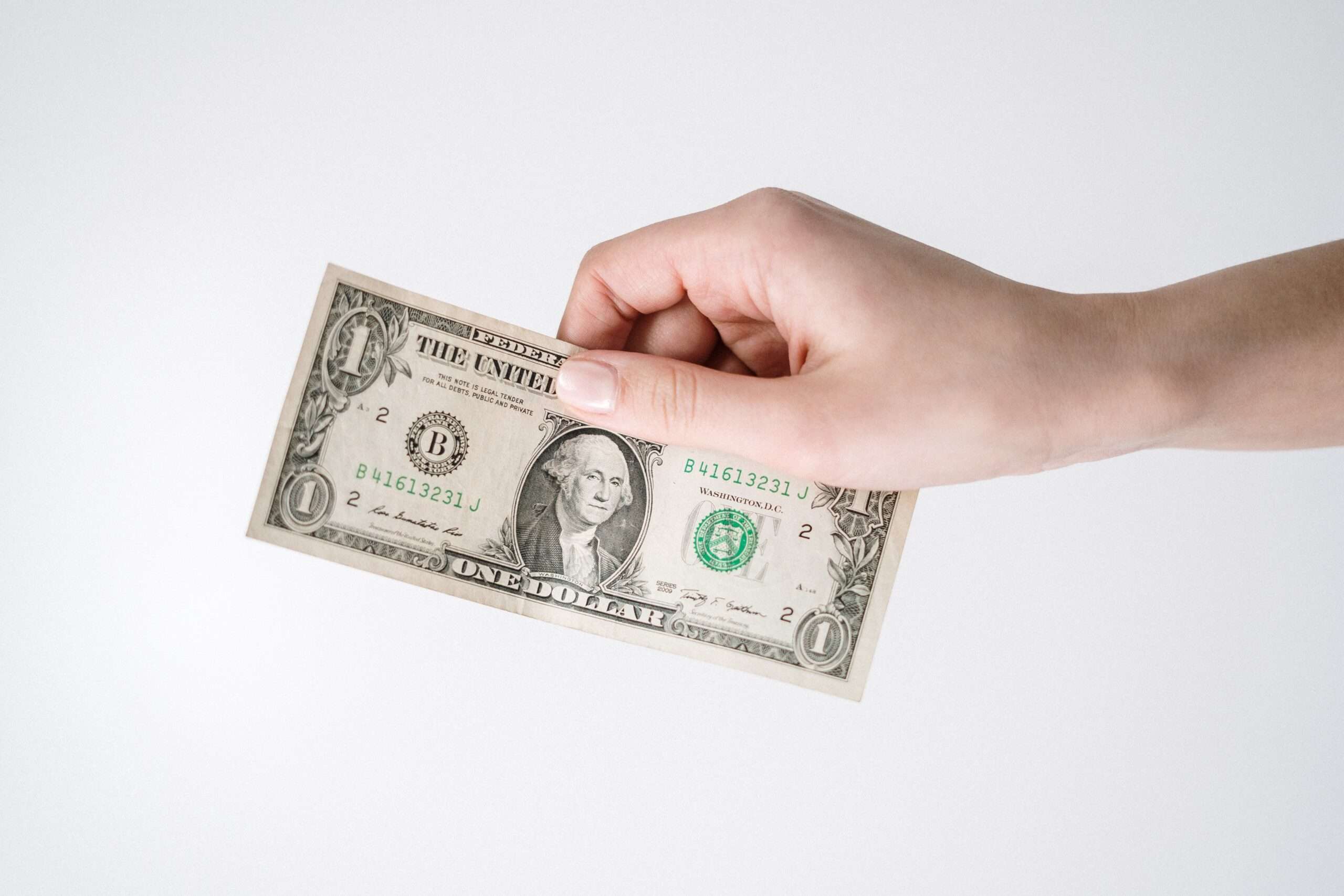 A hand holding a dollar