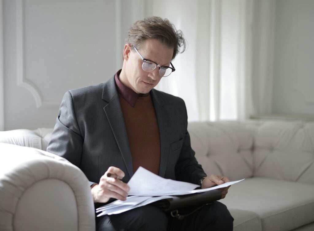 A man in a gray suit looking at a financial document
