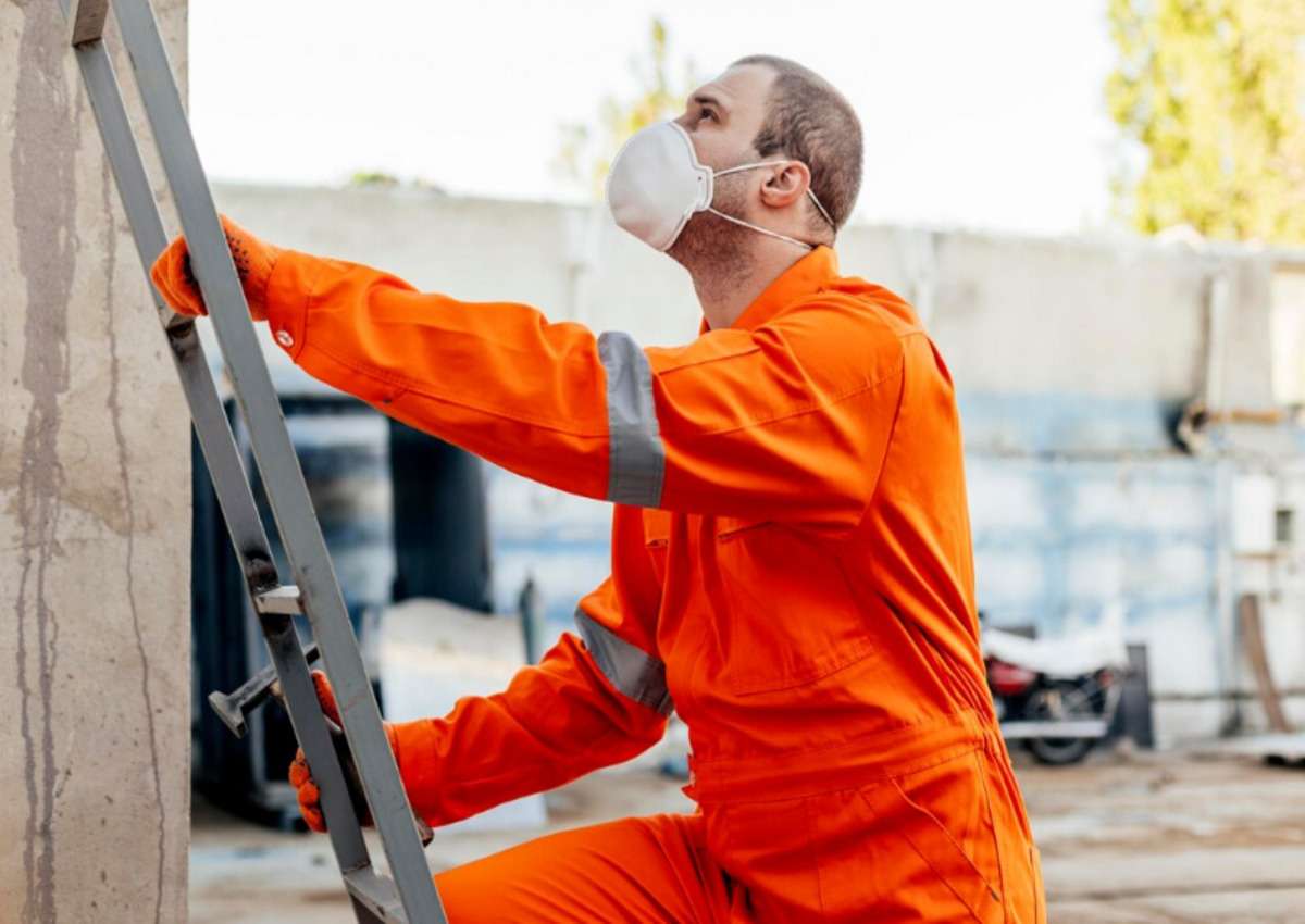 A man doing regular maintenance for his metal barn