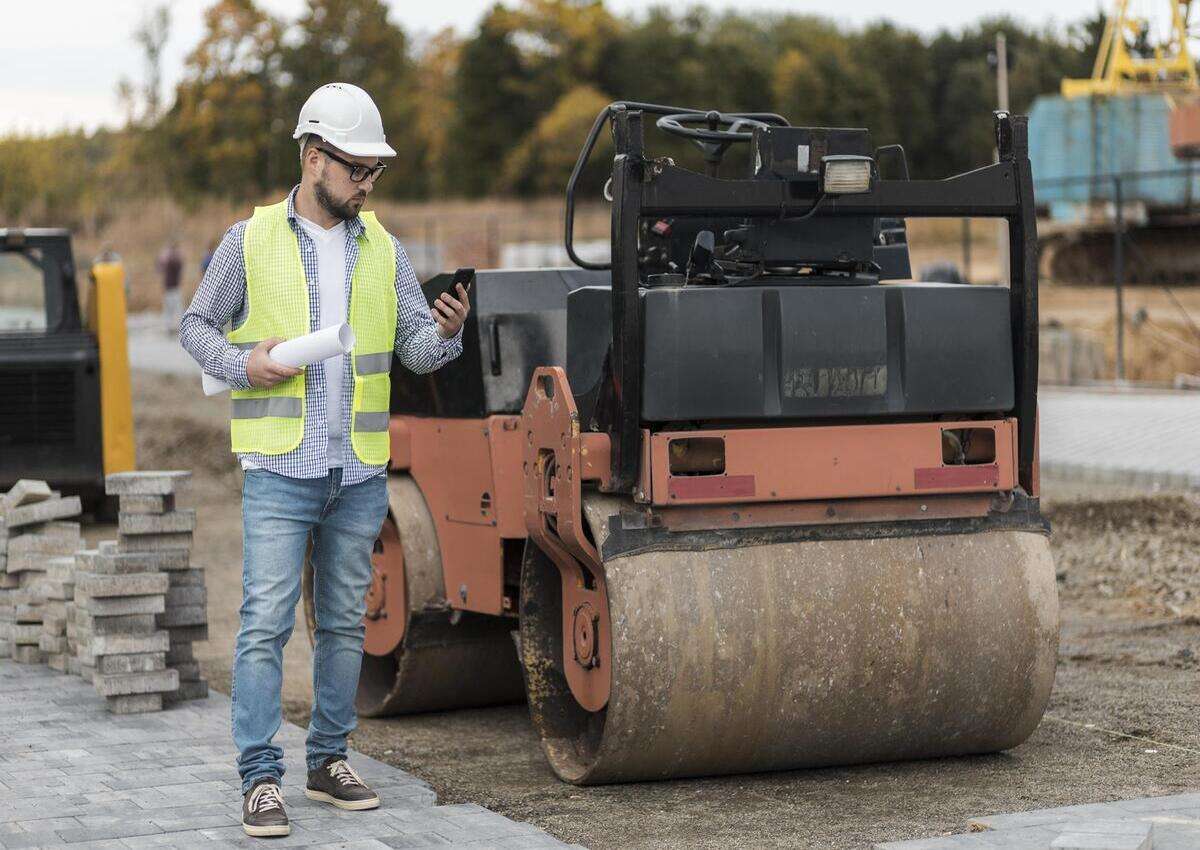 A worker leveling the ground for site construction preparations