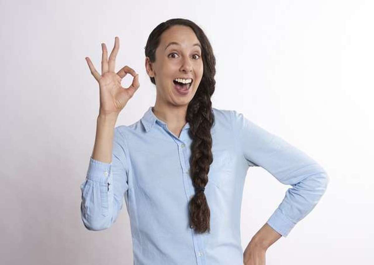 A lady showing an 'okay' sign to indicate how advantageous a metal garage is