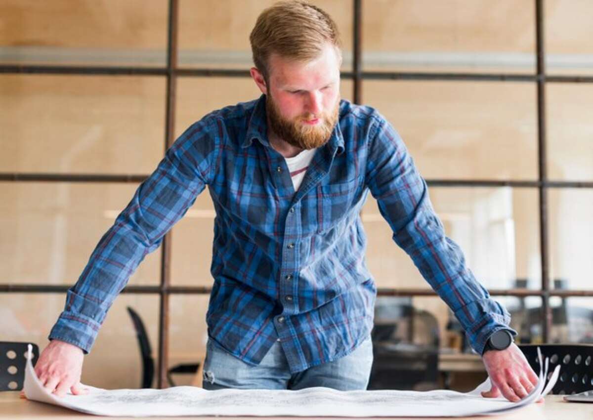 A man working on his metal barn design structure