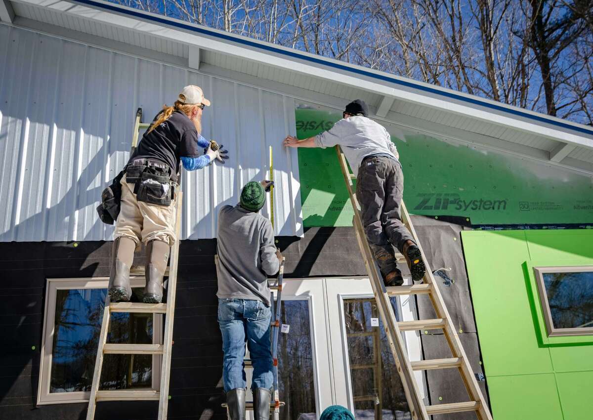 Workers conducting metal barns maintenance