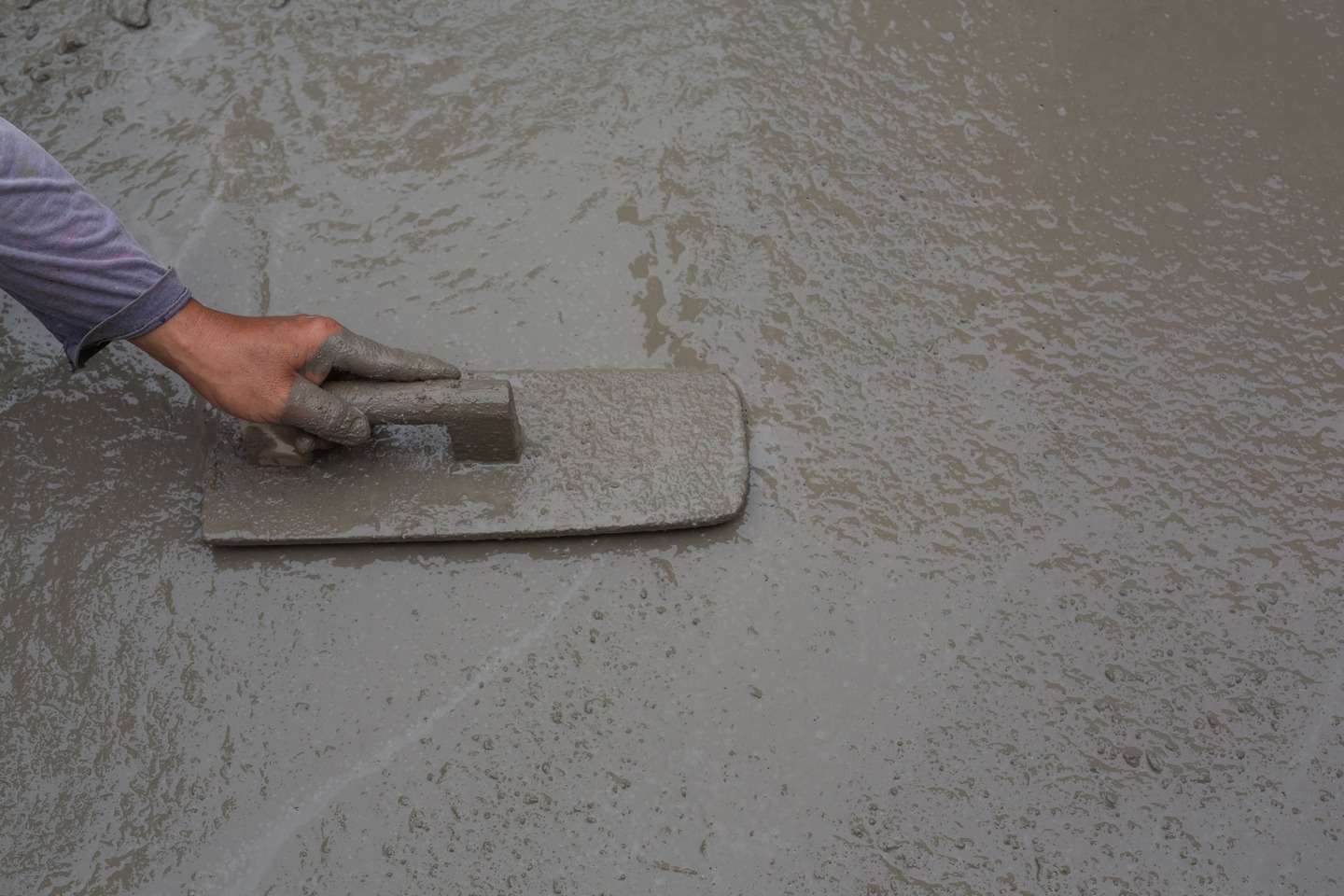 A person leveling the concrete flooring