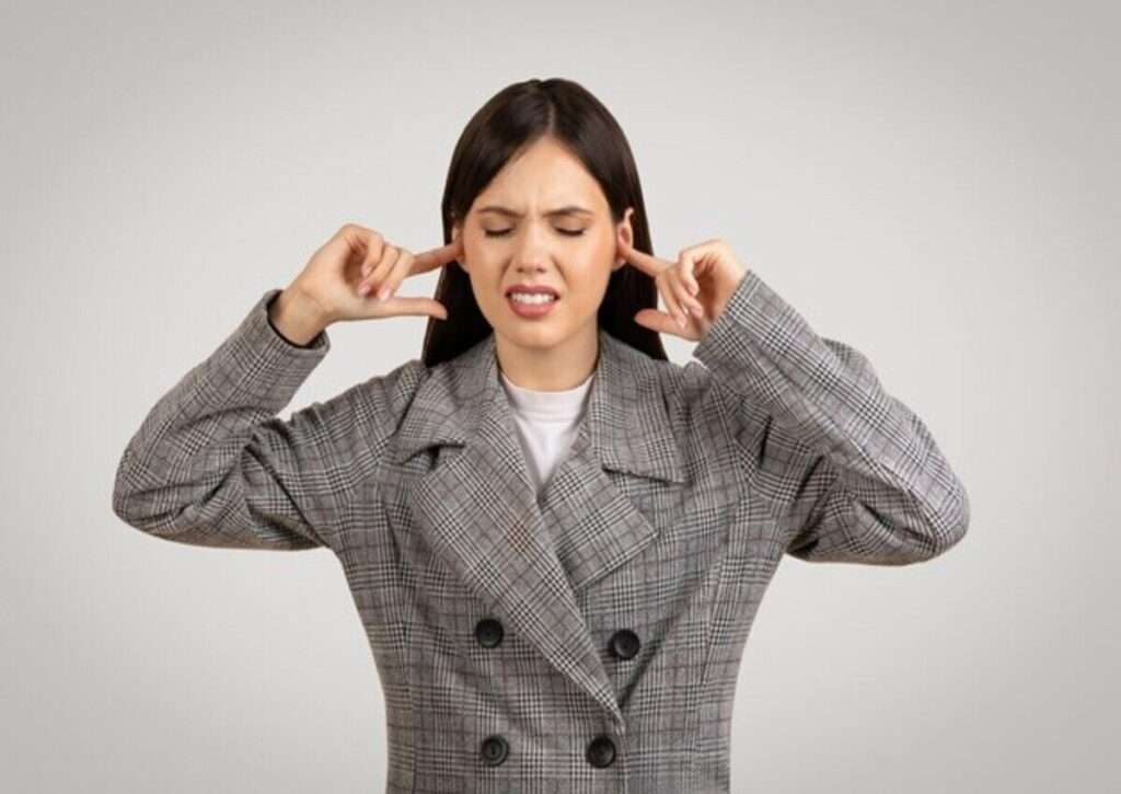 A young worker complaining about loud noise on steel building office