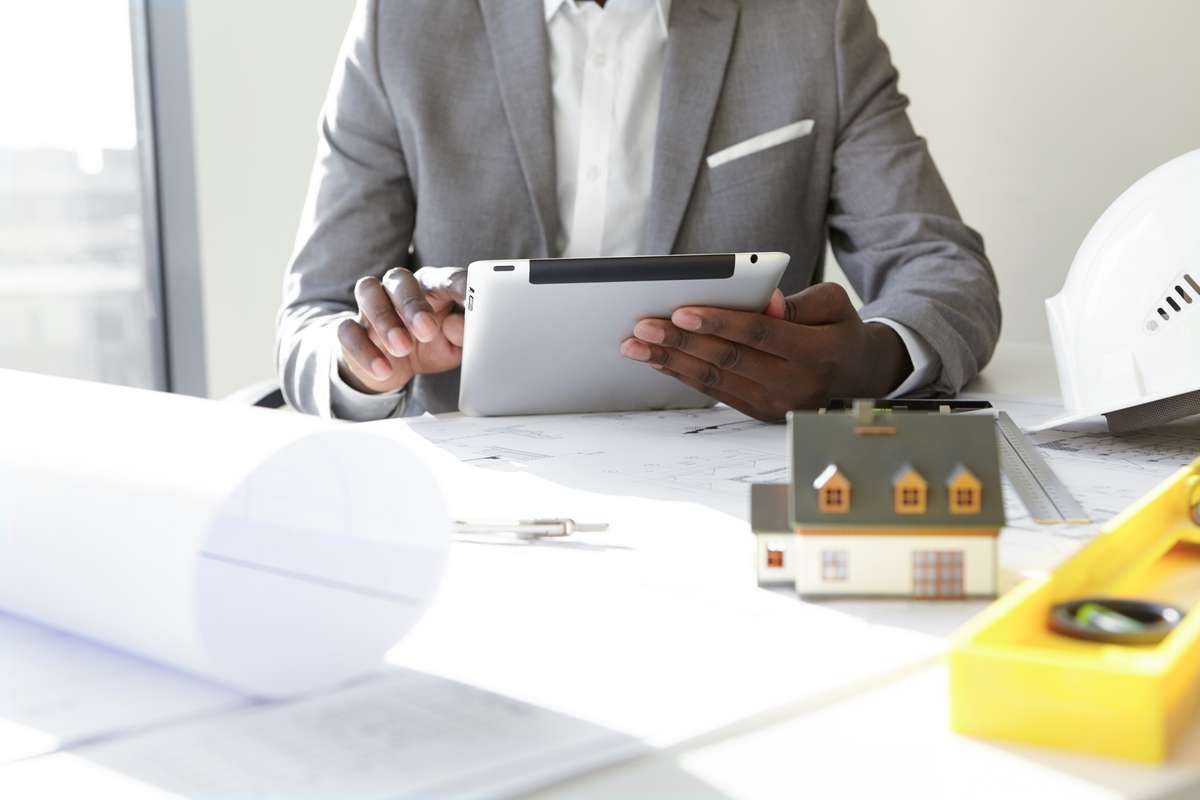 A man using a tablet to check the steel buildings construction project.