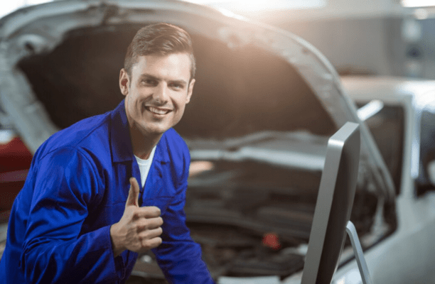 Smiling worker gives thumbs-up about needing a permit for metal garage installation.